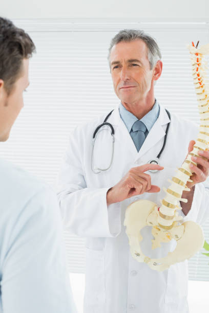 istock Doctor explaining the spine to patient in office 869577086