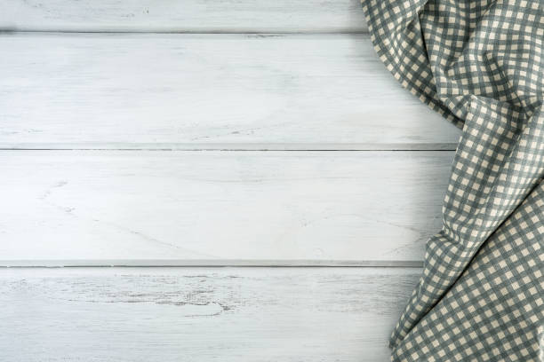 istock Crumpled checkered tablecloth or napkin on empty white wooden table with copy space for food cooking  menu background concept , top view or overhead shot 869577710