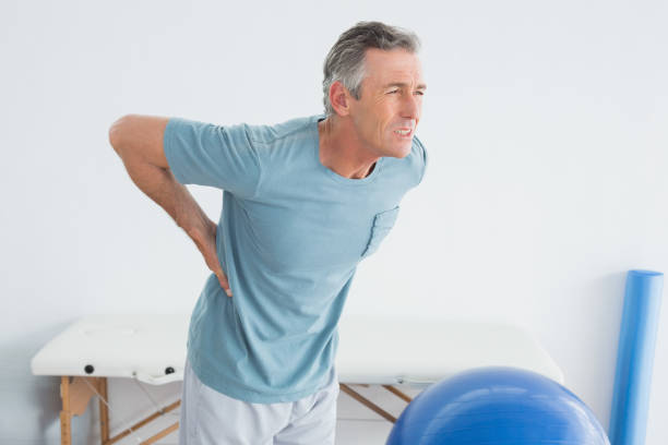 ジムの病院で腰の痛みを持つ男 - lower back pain ストックフォトと画像