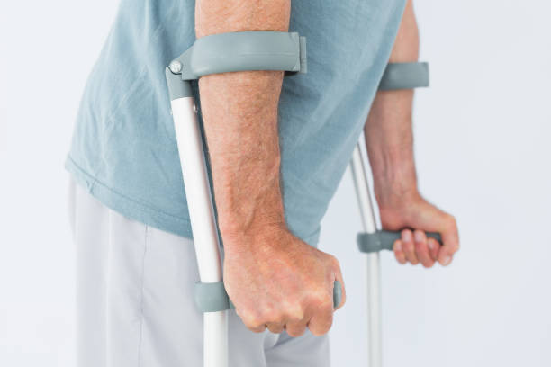 istock Closeup mid section of a man with crutches 869580376