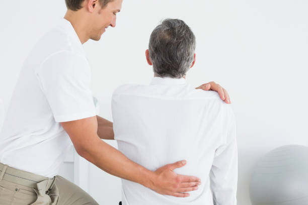istock Male chiropractor examining man 869584030