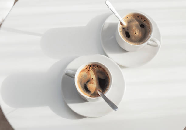 istock two cups of coffee on white table 869584818