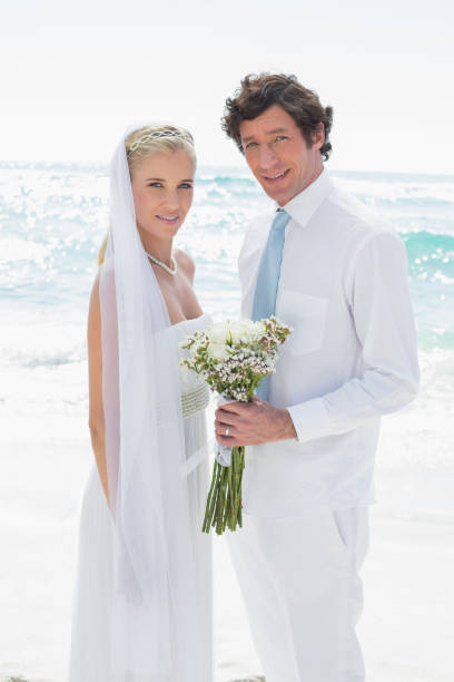 istock Bride and groom smiling at camera 869585048