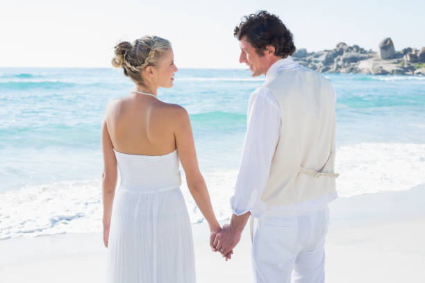 istock Bride and groom holding hands looking at each other 869587396