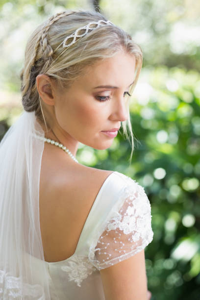 istock Blonde bride in a veil rear view 869591994