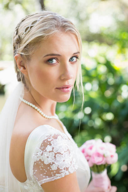 istock Blonde bride in a veil looking to camera 869592004