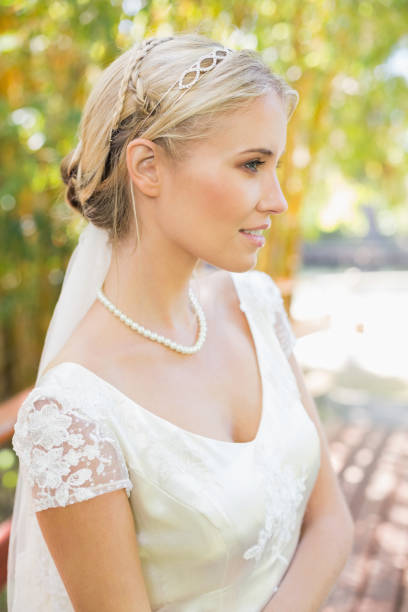 istock Pretty smiling blonde bride standing on a bridge 869595052