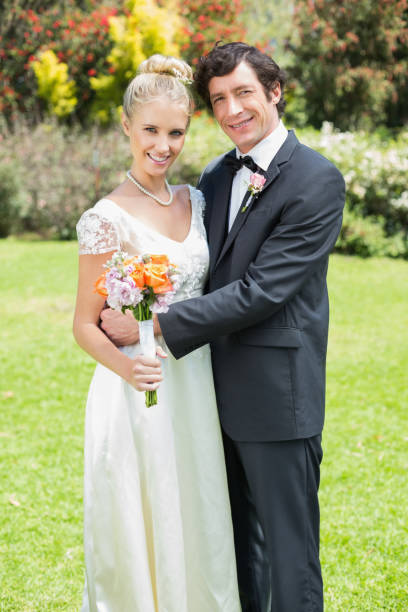 istock Smiling newlyweds embracing each other looking at camera 869595508