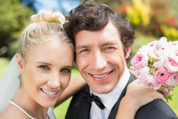 istock Attractive bride and groom smiling at camera 869595694