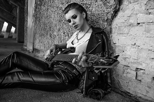 Female rockstar with guitar. Black and white photo . Melancholy