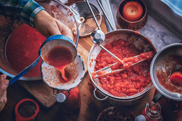 preparando salsa de tomate casera y conservar en botellas - alimento conservado fotografías e imágenes de stock