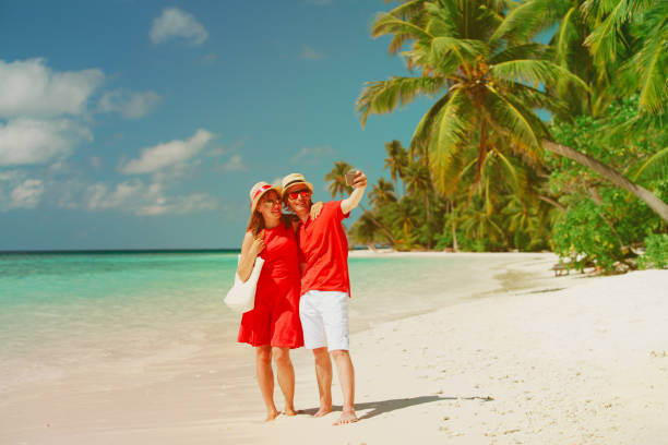 istock Young happy couple making a selfie on beach 869599102