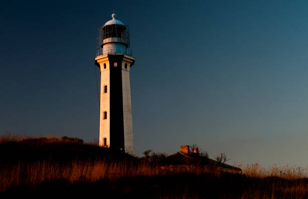 istock Lighthouse tower in the rays of the setting sun 869599786