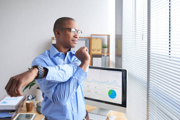 Stretching man Smiling Black business executive stretching his arms during little break break time stock pictures, royalty-free photos & images