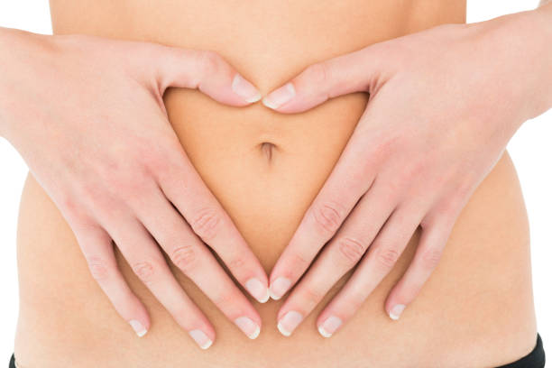 istock Mid section of a fit woman with hands over belly 869607802