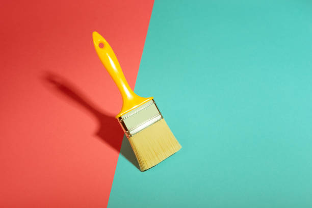 Paint brush levitating on colorful background