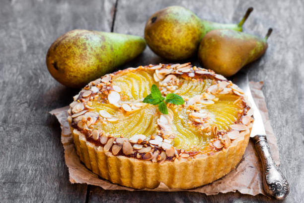 Delicious  cake with half poached pears and almond flakes
