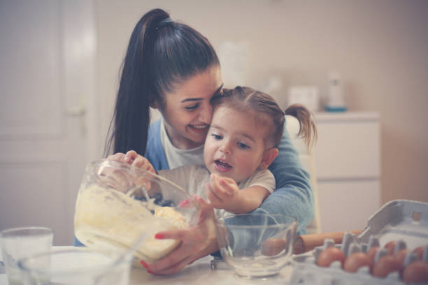 istock Young mother and daughter baking cookie and mixing dough. 869617378
