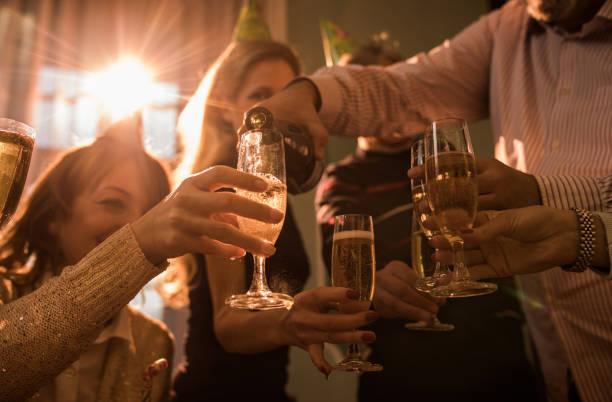 istock Group of people having fun on a party while pouring champagne. 869618696