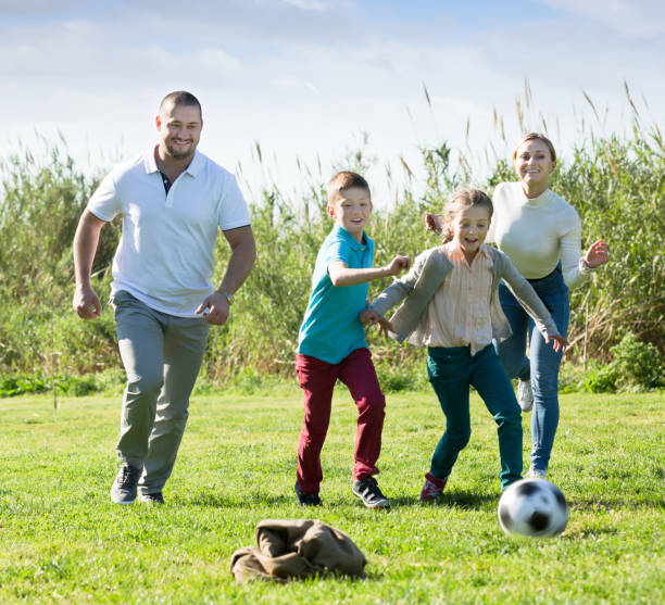 istock Smiling parents with two kids playing soccer 869619986