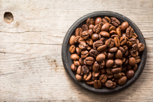 istock Roasted coffee beans on black plate on wooden background 869622892