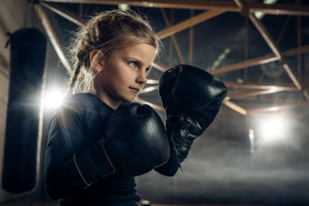 istock Determined little girl in a fighting stance on boxing training. 869626110