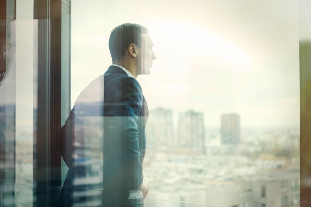istock Business man looking out through the office balcony seen through glass doors. Post processed with vintage filter. 869629256