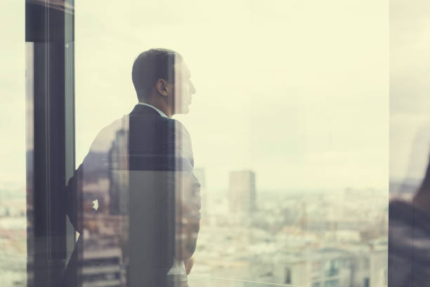 istock Business man looking out through the office balcony seen through glass doors. Post processed with vintage filter. 869629298