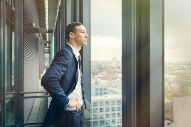 istock Business man looking out through the office balcony. Post processed with vintage filter. 869629522