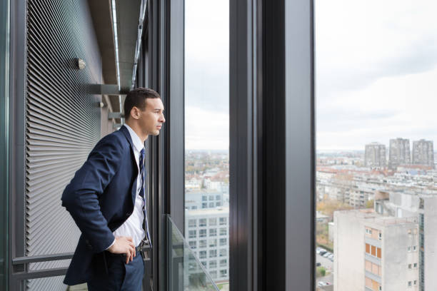 istock Business man looking out through the office balcony. 869630664