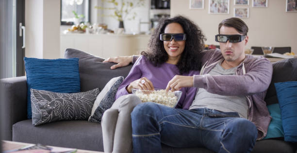 istock Young couple watching TV with 3D glasses 869630784