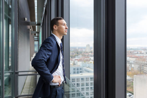 istock Business man looking out through the office balcony. 869630858