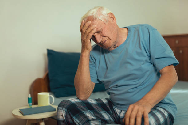 istock Senior Man Sitting On Bed At Home Suffering From Depression 869637506