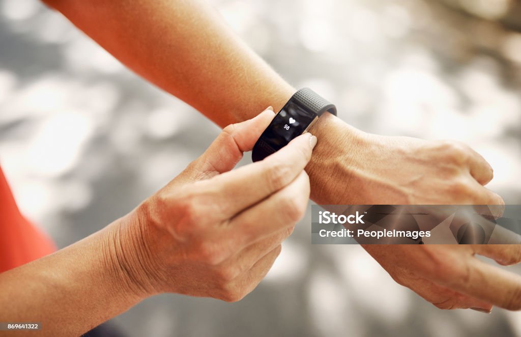 The best piece of tech for your wrist Shot of an unrecognizable woman checking her fitness tracker after a run Fitness Tracker Stock Photo