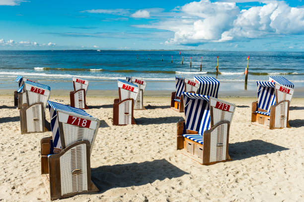 Hooded beach chairs at island Norderney at North Sea Hooded beach chairs at island Norderney at North Sea hooded beach chair stock pictures, royalty-free photos & images