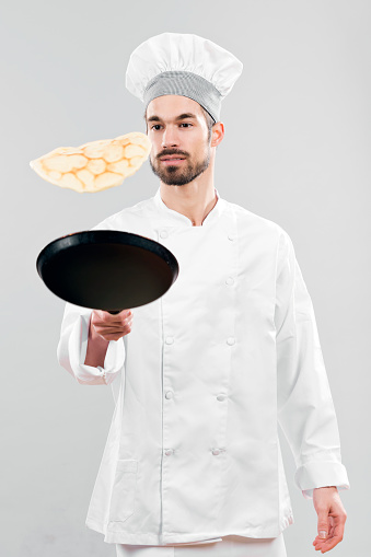 Chef flipping pancakes on gray background