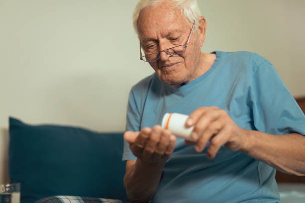 istock Senior Man Sitting On Bed At Home Taking Medication 869642236