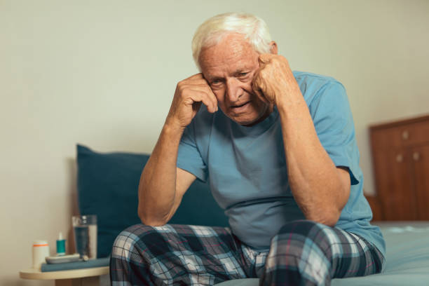 istock Senior Man Sitting On Bed At Home Suffering From Depression 869645174