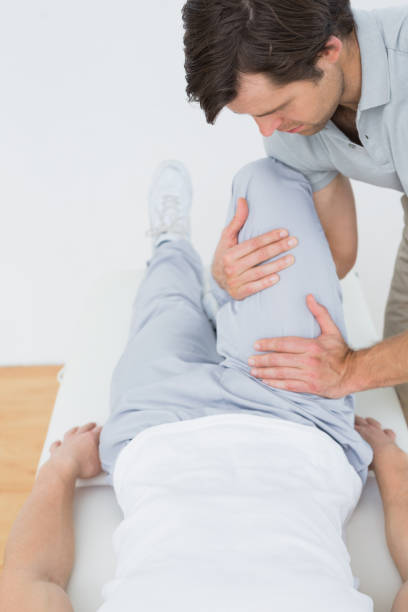 istock Male physiotherapist examining a mans leg 869645228