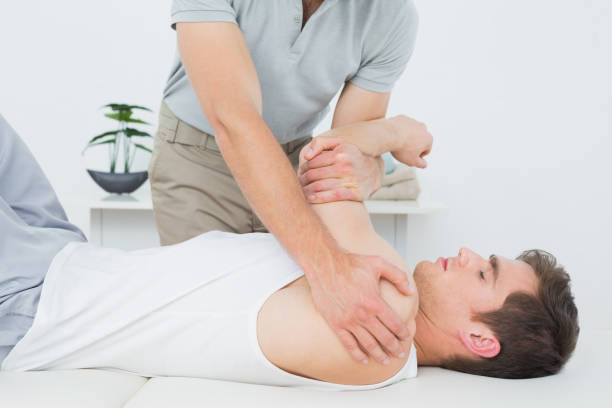 istock Male physiotherapist examining a mans hand 869645362