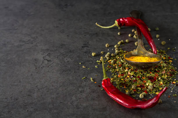 istock Set of Various spices on black stone table. Chilly pepper,  basi 869645520
