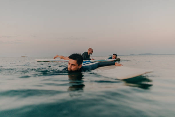 istock Friends surfing in the ocean 869654650