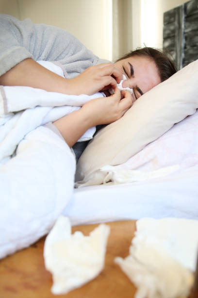 istock Woman Suffering From Cold Lying In Bed With Tissue 869655126
