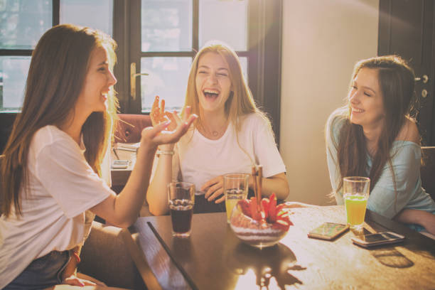 adolescentes felices hablando y riendo en un café. - coffee buzz fotografías e imágenes de stock