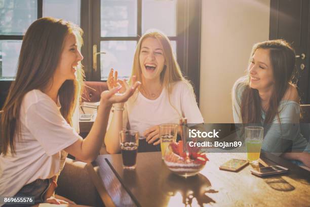 Happy Teenage Girls Talking And Laughing In A Cafe Stock Photo - Download Image Now