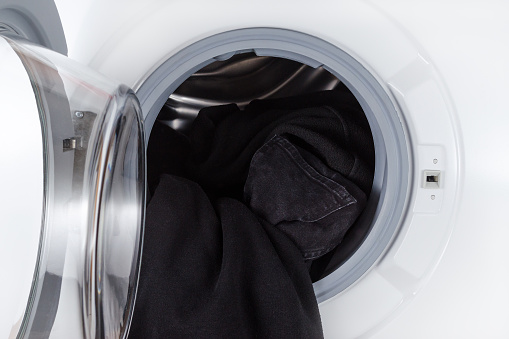 washing black clothes, open door wash machine closeup