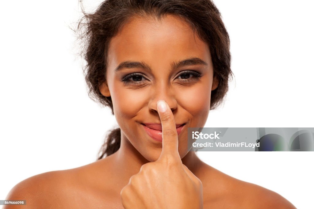 Young dark skinned woman touching her nose Nose Stock Photo