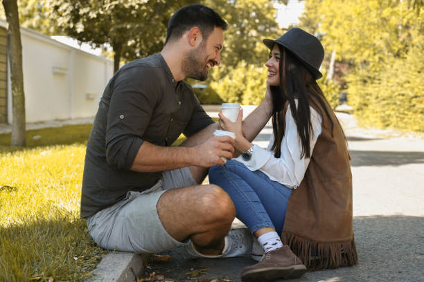 istock Young couple drinking coffee on street sidewalk. 869666844