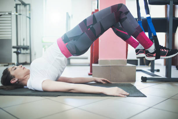 istock Attractive young woman is doing plank exercise while working out in gym 869670140
