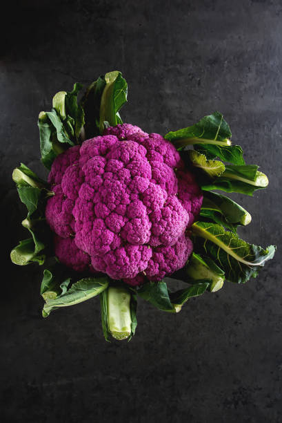 chou-fleur vert et le violet. fond sombre. nourriture végétarienne. - purple cauliflower photos et images de collection